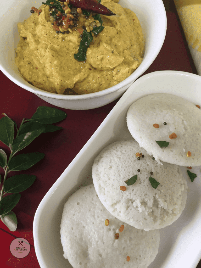 Idli is a steamed rice-lentil dish ((sometimes millets) made in South India and is oil free, gluten free and vegan too. Served for breakfast with sambar or chutney