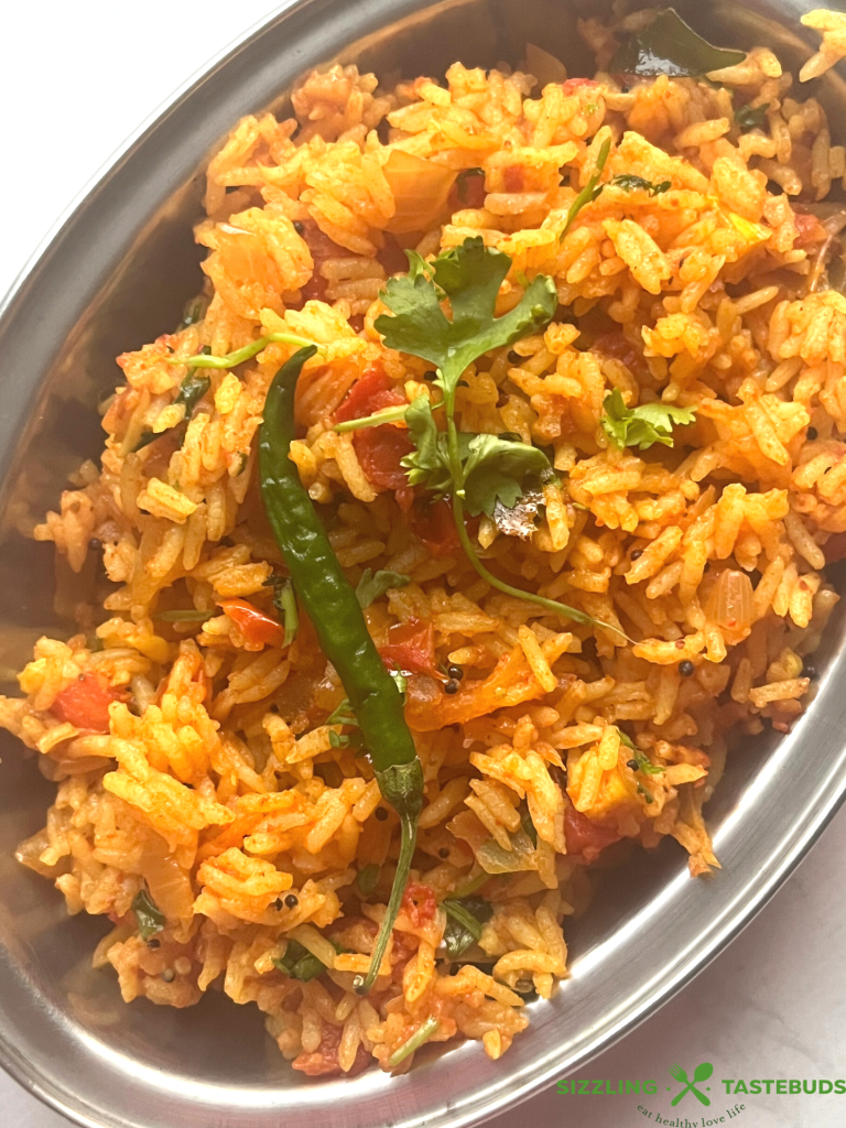 Tomato Rice is a gluten free, Vegan and Easy One Pot meal made with tomatoes, Cooked rice and everyday spices. Works for lunchbox or potluck too.