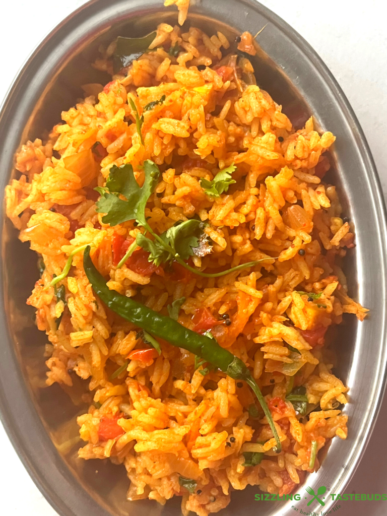 Tomato Rice is a gluten free, Vegan and Easy One Pot meal made with tomatoes, Cooked rice and everyday spices. Works for lunchbox or potluck too.