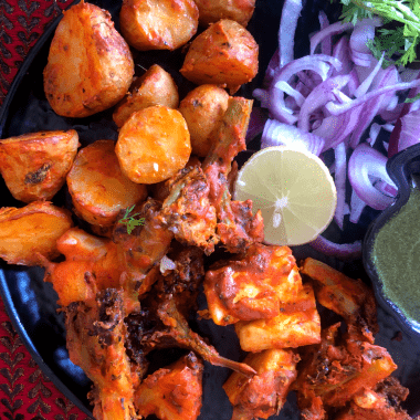 Tandoori Aloo is a gluten free snack made with marinated baby potatoes baked in a Tandoor (or an oven) and served with a spicy-tangy coriander mint sauce and a salad on the side.