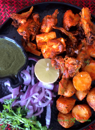 Tandoori Aloo is a gluten free snack made with marinated baby potatoes baked in a Tandoor (or an oven) and served with a spicy-tangy coriander mint sauce and a salad on the side.