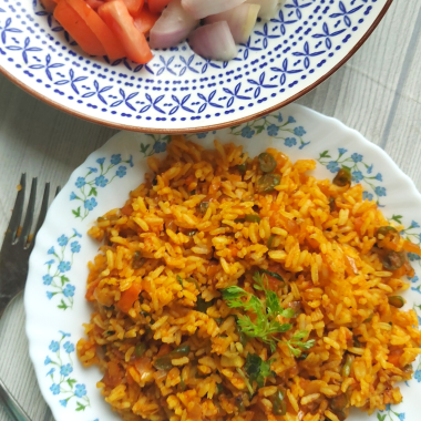 Jollof Rice is a quick One Pot meal that is bursting with spices, peppers and is usually served as main Course with meat / veggie sides