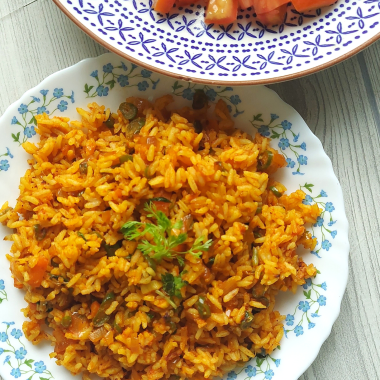 Jollof Rice is a quick One Pot meal that is bursting with spices, peppers and is usually served as main Course with meat / veggie sides