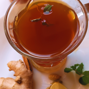 Sulaimani tea, a milkless spiced black tea from Kerala's Malabar region with Arab roots, features a golden hue from warm spices and lemon juice.
